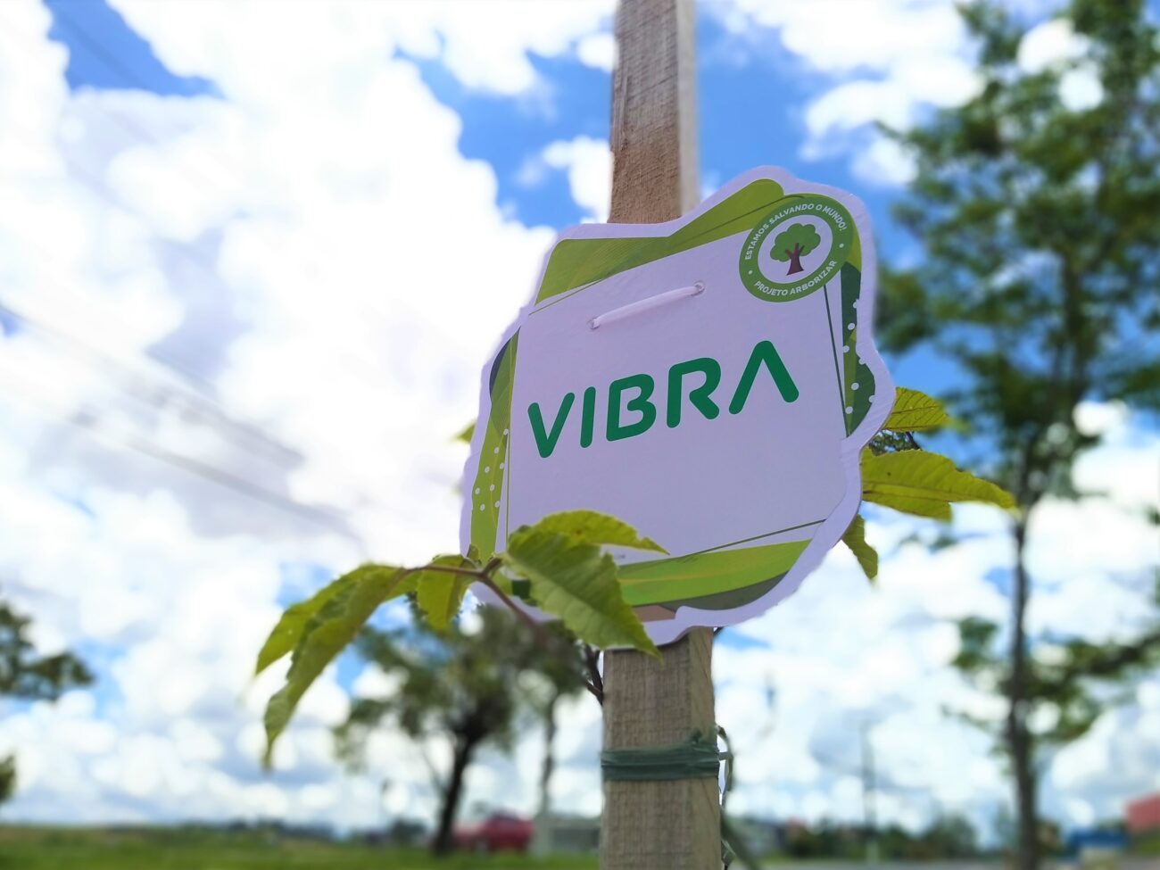 Foto da logo Vibra em uma placa de rua demonstrando apoio ao projeto arborizar